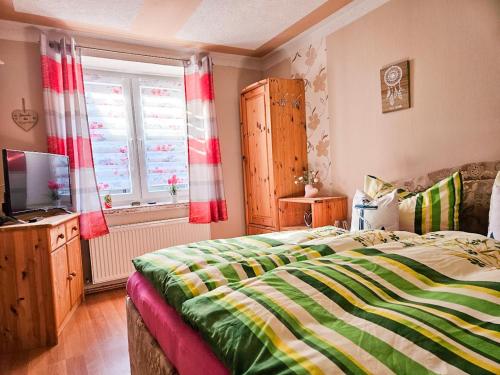 a bedroom with a bed and a television and a window at Ferienhaus Geli 4 in Kröslin