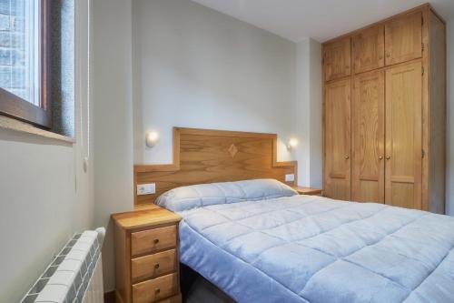 a bedroom with a bed and a wooden cabinet at Valle del Ibias - Primero Izquierda in Cecos