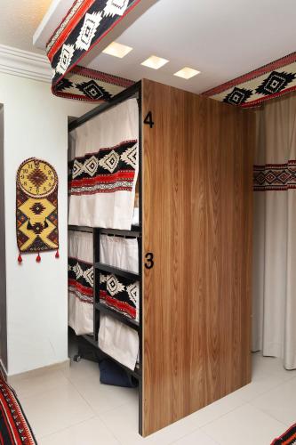 a room with a closet with a wooden door at Sands Inn Hostel - City Center in Riyadh