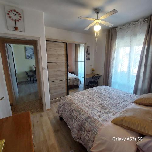 a bedroom with a bed and a ceiling fan at NATALI Appartamens Rosa in Malcesine