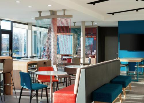 a restaurant with tables and chairs and a flat screen tv at avid hotel Coralville - Iowa City by IHG in Coralville