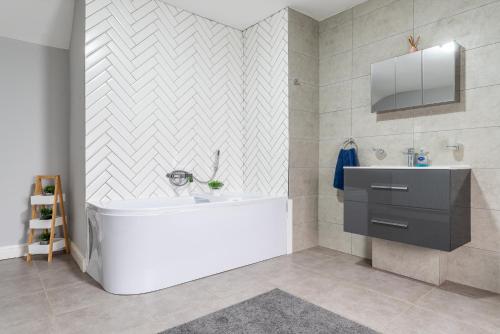 a bathroom with a white tub and a sink at Airfield Manor in Castle Donington