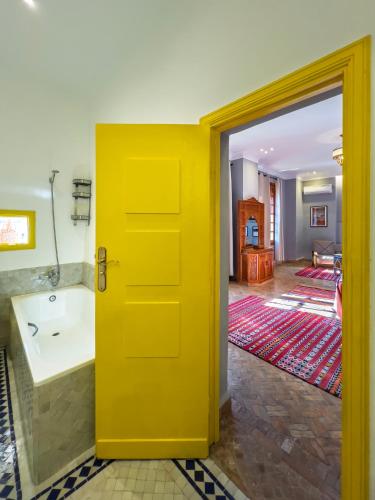 a yellow door in a room with a bathroom at RIAD TANJA by chef Moha in Tangier