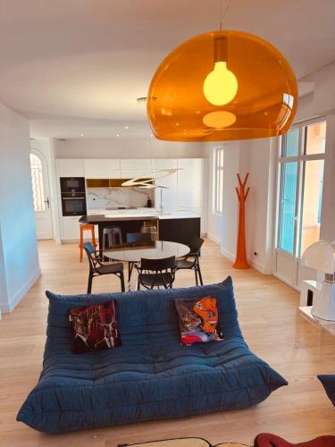 un salon avec un canapé bleu et une table dans l'établissement Prestige Ste Maxime centre ville, à Sainte-Maxime