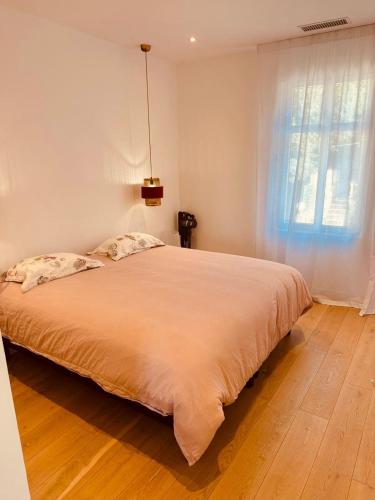 une chambre avec un grand lit avec une grande fenêtre dans l'établissement Prestige Ste Maxime centre ville, à Sainte-Maxime