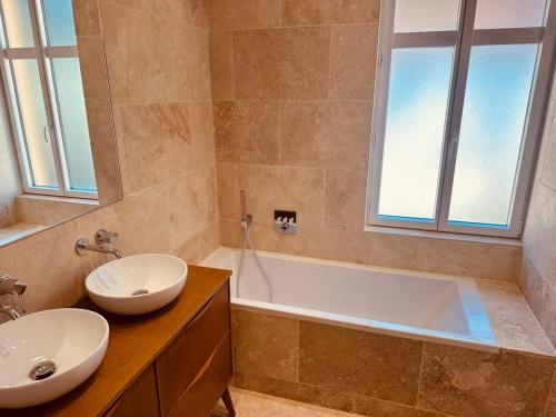 La salle de bains est pourvue d'un lavabo et d'une baignoire. dans l'établissement Prestige Ste Maxime centre ville, à Sainte-Maxime