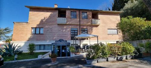 a large brick building with an umbrella in front of it at Hotel I Platani in Siena
