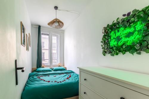 une chambre avec un lit et un mur végétal dans l'établissement Cinéma Love Paris, à Paris