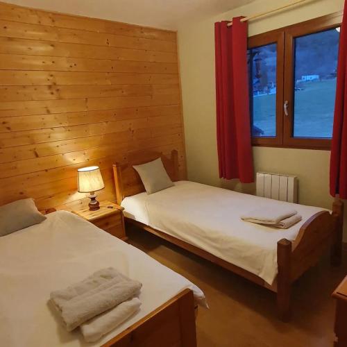 une chambre avec deux lits et une lampe et une fenêtre dans l'établissement Appartement spacieux à Séez 130 m², proche des montagnes, à Séez
