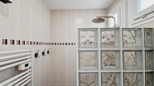 ein Bad mit einer Dusche und Glasblockfenstern in der Unterkunft Le Rivage, maison proche mer avec Spa in Les Sables-dʼOlonne