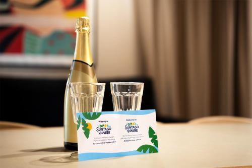 a bottle of champagne and two glasses on a table at Suntago Village - Oficjalny nocleg Suntago in Mszczonów