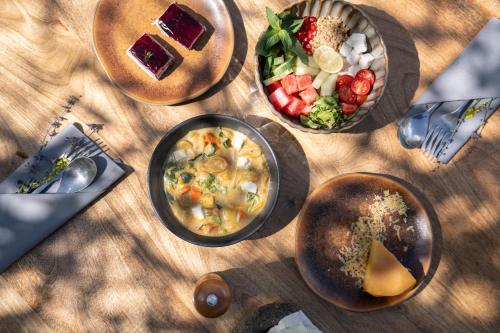 a table topped with bowls of food and a salad at Stone Hedge Hotel in Nubra