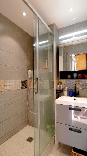une salle de bain avec une douche en verre et un lavabo dans l'établissement L'ENVOLéE, à Samoëns