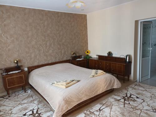 a bedroom with a bed and two dressers at Guest House Stoletnika in Yagodina