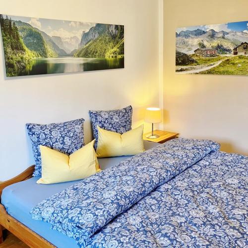 a bedroom with a blue bed with two pillows at Open Garden Mountain Lodge in Oberaudorf