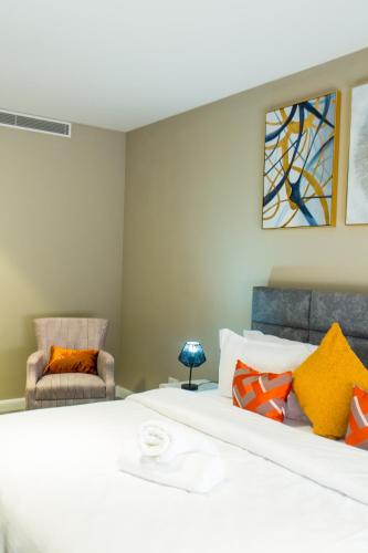 a bedroom with a large white bed with colorful pillows at Accra Luxury Apartments @ Pearl in Accra