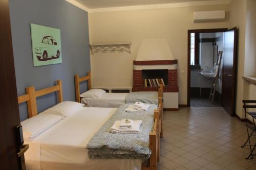 a bedroom with two beds and a fireplace at Cascina La Goliarda in Curtatone