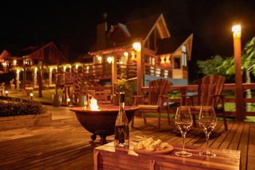 a bottle of wine and wine glasses on a wooden deck at Hospedaria Morada das Grimpas in Palmeira