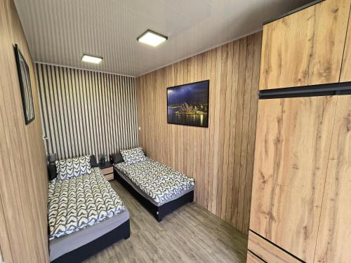 two beds in a room with wooden walls at Nowy York - Sauna - Jacuzzi - Najczystsze jezioro PL - SPA - STYRUŚ in Giewartów