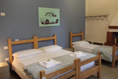 a bedroom with two beds and a van on the wall at Cascina La Goliarda in Curtatone