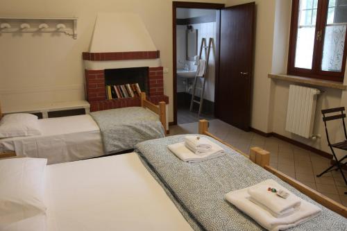 a bedroom with two beds and towels on a table at Cascina La Goliarda in Curtatone