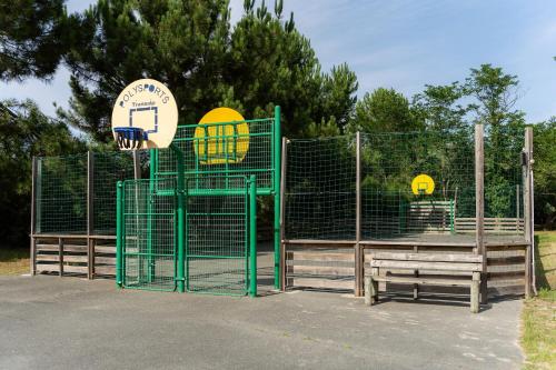 a gate with a basketball hoop in a park at Camping La Pointe du Médoc in Le Verdon-sur-Mer