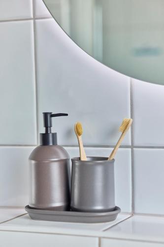 a bathroom counter with two toothbrushes and a soap dispenser at Mira - stillvolle Wohnung im Zentrum von Bretten in Bretten