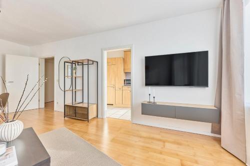 a living room with a flat screen tv on a wall at Mira - stillvolle Wohnung im Zentrum von Bretten in Bretten