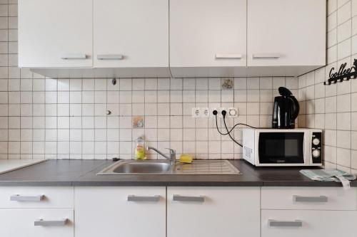 a kitchen with a sink and a microwave at Yellow in Miltenberg