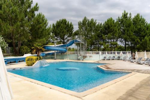 a swimming pool with a slide in a resort at Camping La Pointe du Médoc in Le Verdon-sur-Mer