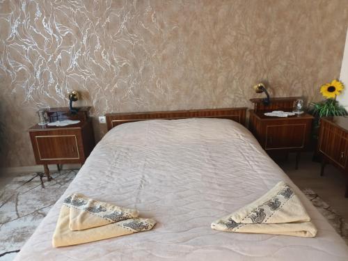 a bed with two tables and two towels on it at Guest House Stoletnika in Yagodina