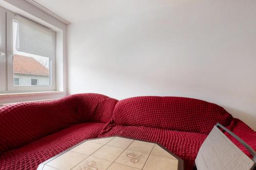 a red couch in a room with a window at Yellow in Miltenberg