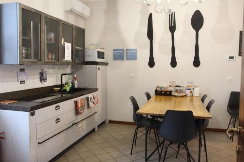 a kitchen with a table and utensils on the wall at Cascina La Goliarda in Curtatone