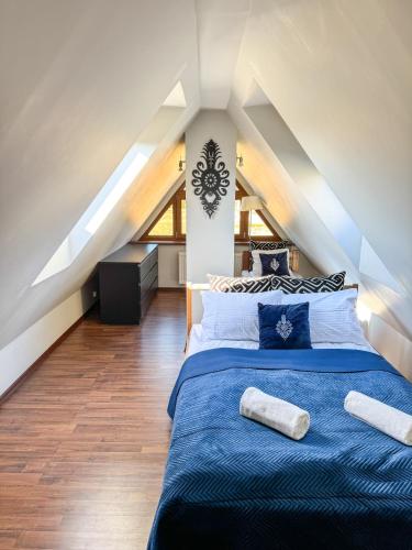 a bedroom with a blue bed in a attic at Willa Chrycówka - Jacuzzi, Basen, Sauna in Kościelisko