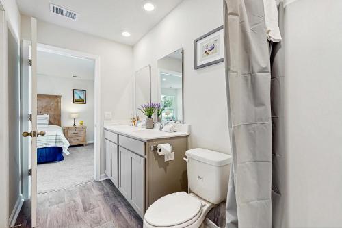 a bathroom with a toilet and a sink and a mirror at Whispering Breeze in Ocean Isle Beach