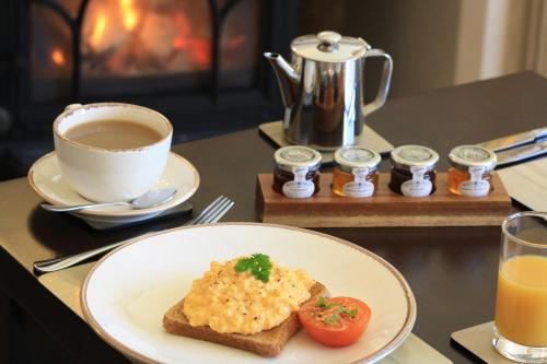 ein Tisch mit einem Teller Essen und einer Tasse Kaffee in der Unterkunft The Rectory Lacock - Boutique Bed and Breakfast in Lacock