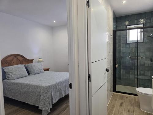 a bedroom with a bed and a bathroom with a sink at Casa Balcon 2 bedroom by El Sirocco in Puerto de Mogán