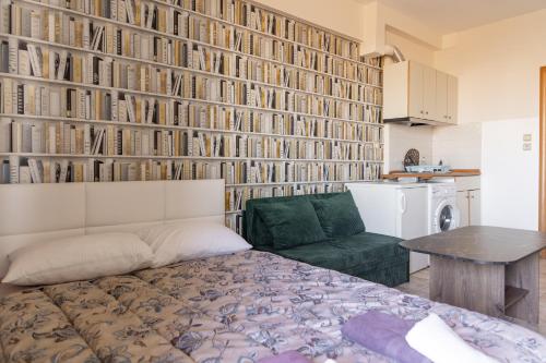 a bedroom with a bed and a wall of books at Elia mini Suite 3 in Larisa