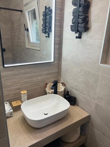 a bathroom with a white sink and a mirror at Little Oasis in Baška