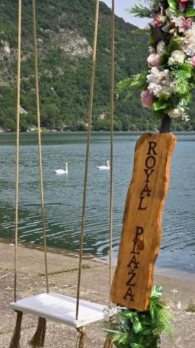 a swing with a sign on it next to a lake at Hotel Royal Drina in Mali Zvornik