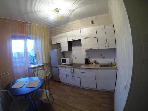 アバカンにあるApartment NG Na Torosovaの小さなキッチン(白いキャビネット、テーブル、テーブル付)