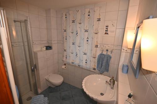 a bathroom with a sink and a toilet and a shower at Appartement Fischer un sin Fru in Warnemünde