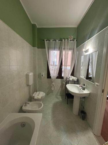 a bathroom with a tub and a toilet and a sink at La Magnolia - Rooms in Verona