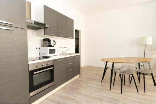 une cuisine avec une table en bois et une table ainsi qu'une salle à manger dans l'établissement Charming T2 - heart city center, à Marseille