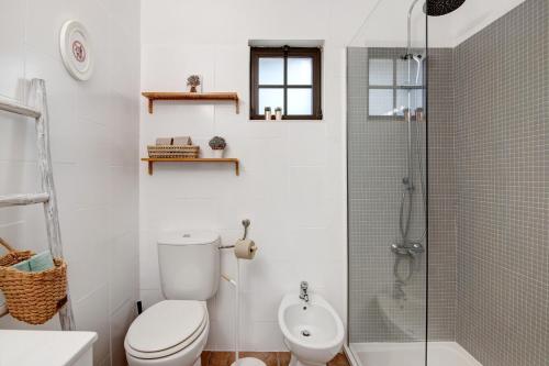 une salle de bain blanche avec toilettes et douche dans l'établissement Casa Lavadeira - Vinhas De Nexe, à Faro