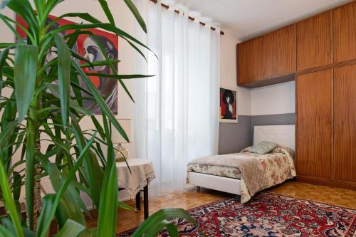 a bedroom with a bed and a potted plant at appartamento Monika con parcheggio in Volano