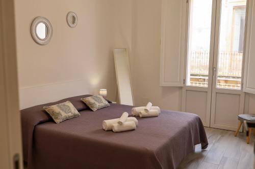 a bedroom with a bed with two towels on it at Don Camillo Maison in Avola