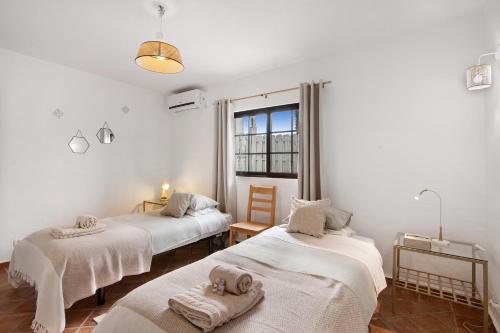 une chambre avec deux lits avec des serviettes dessus dans l'établissement Casa Lavadeira - Vinhas De Nexe, à Faro