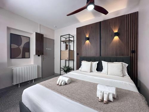 une chambre avec un grand lit blanc avec un ventilateur de plafond dans l'établissement Porte de Versailles - Studio pour 2, à Paris