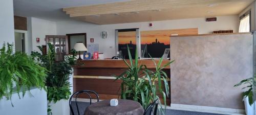 a lobby with a counter and plants in a room at Hotel I Platani in Siena